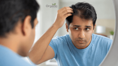 आईने में अपनी हेयरलाइन चेक करता व्यक्ति, जेनेटिक hair fall के संकेतों को दर्शाता हुआ